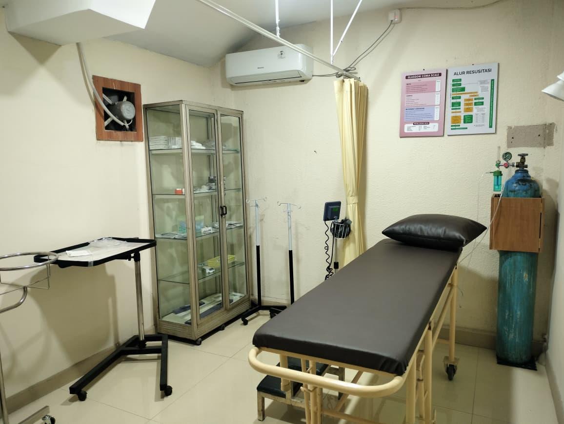 Ruang tindakan dengan tempat tidur, tabung oksigen, dan lemari alat medis